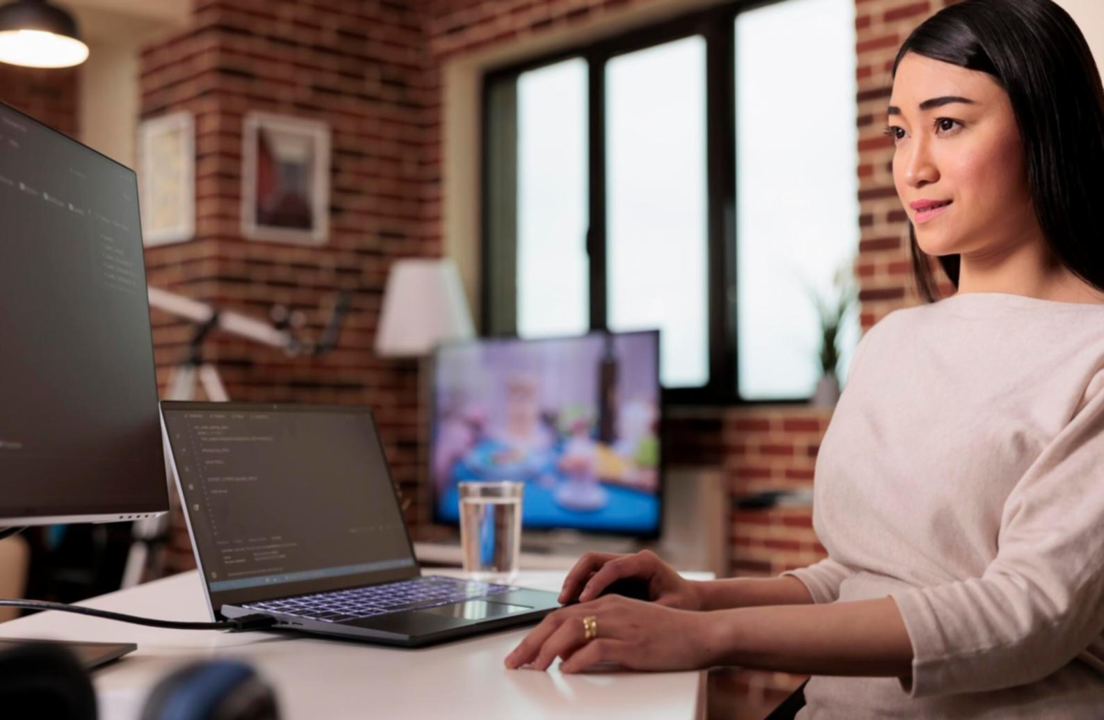 Designer reviewing typography layouts and web interface prototypes on multiple screens